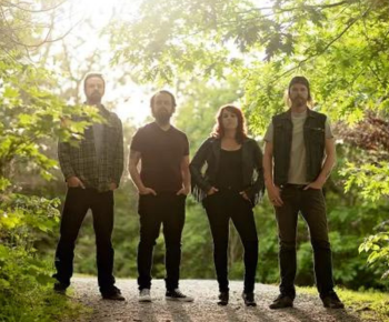 Kilmore band on a outdoor trail with a vibrant forest background and sunlight breaking through the trees.