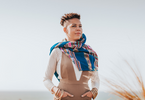 A woman with a floral scarf looks out over the horizon.