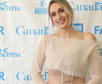 Nicole Ariana holding one of her awards in front of a Music Nova Scotia backdrop.