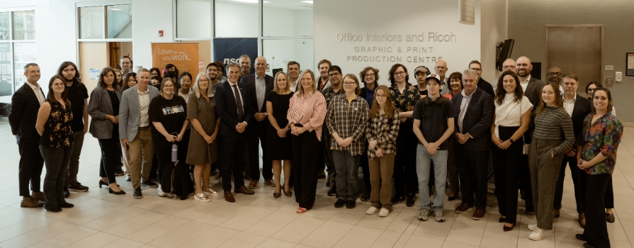 Photo from Office Interiors and RICOH celebration event with their employees and NSCC employees and students in front of the Office Interiors and RICOH Graphic and Print Production Centre at Ivany Campus.