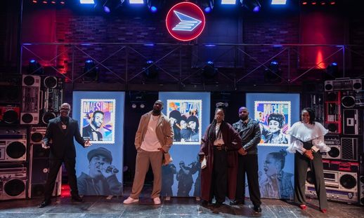 Three men and two women are posing on stage.