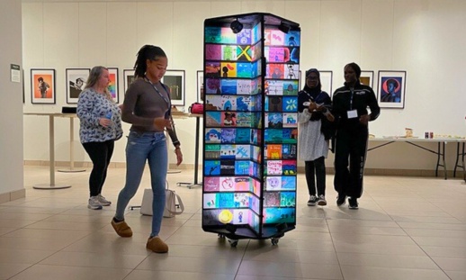 Art display illuminated with tile artwork as attendees explore the exhibit.