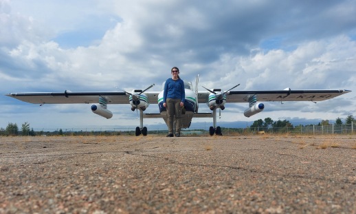 A woman standing in front of a small aircraft equipped with the lidar system.