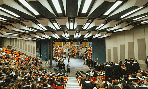 A wide angle photograph of an NSCC Convocation ceremony taking place in a round auditorium.