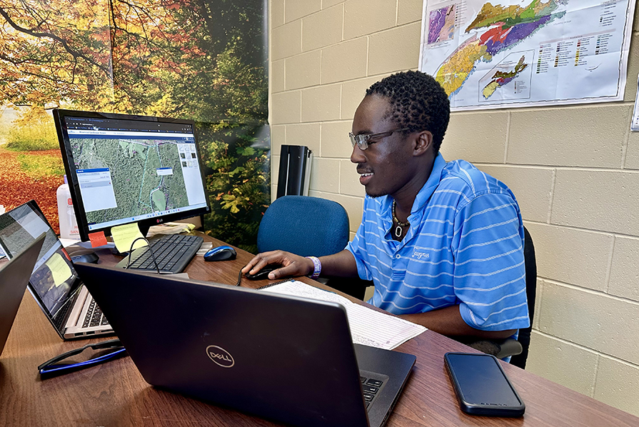 Victor Opadele uses mapping software on a computer.