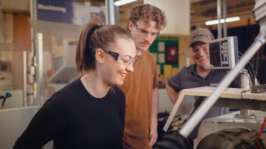 2023-24 NSCC Foundation and Alumni Relations Annual Report cover photo of an NSCC student, alumni and faculty in machining workshop.