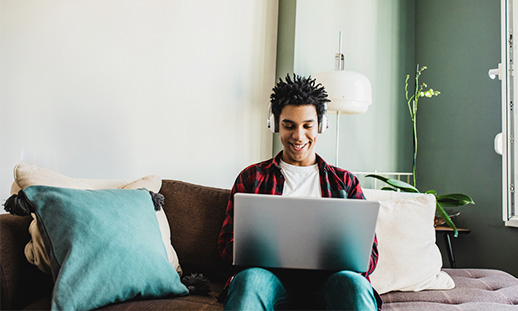 A person sitting on a couch using a computer.