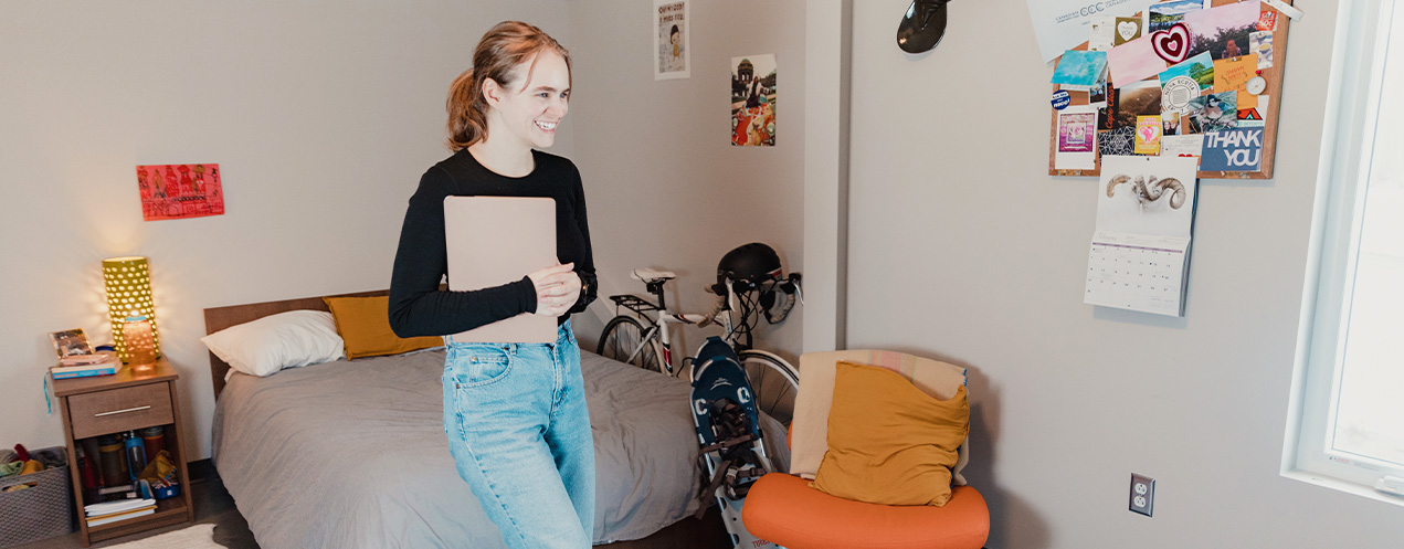 Student standing on mat in campus housing room