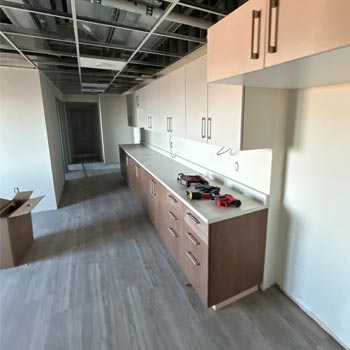 Photo shows a student dorm under construction with cabinets.