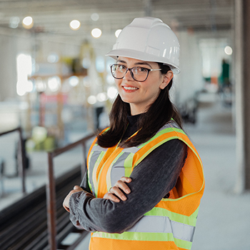 A woman wearing a hard hat and a safety vest.