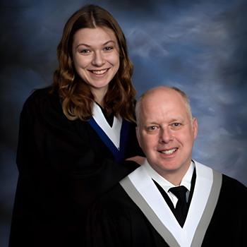 Scott and Genevieve MacKay wearing their grad gowns.