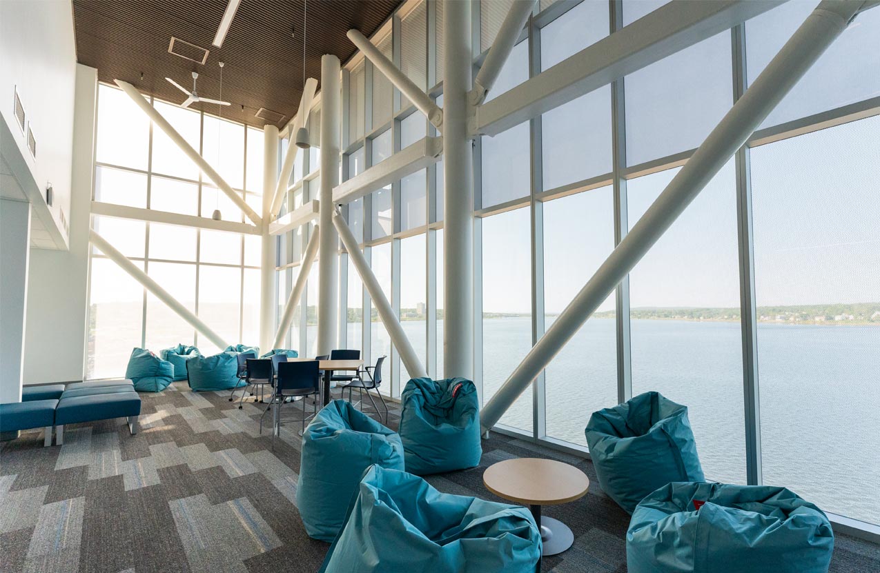 Photo shows floor to ceiling windows with study spaces for students and bean bag chairs at NSCC Sydney Waterfront Campus.