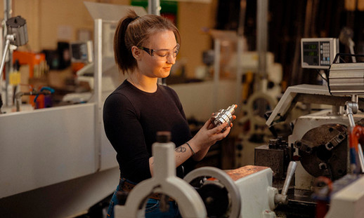 An NSCC Precision Machining graduate works as a Machinist in a workshop.