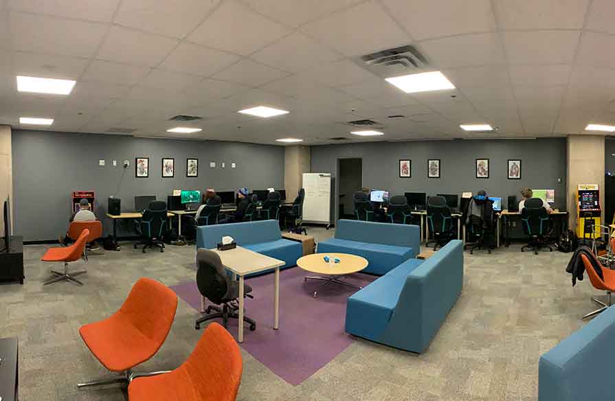 Picture of a big room with chairs and couches and gaming equipment.