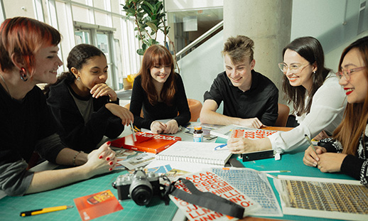 A group of students work together at a table in a study area of an NSCC campus.