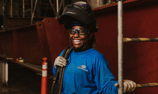 A portrait of an NSCC graduate smiling toward the camera at Irving Shipbuilding in Nova Scotia.