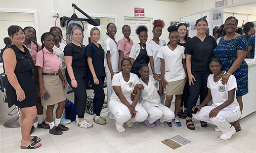 A group of Cosmetology students taking part in a learning exchange pose for a group photo.