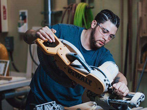 A student uses a saw during a carpentry class at NSCC.