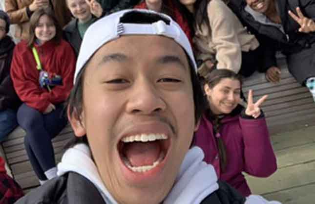 A headshot selfie of a smiling Gabe in front of all his classmates.