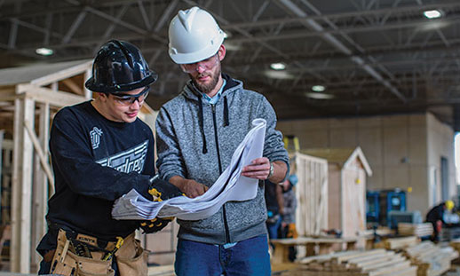 Two students in one of NSCC’s carpentry programs look at printed construction plans.