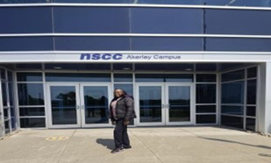 Josephine standing in front of NSCC Akerley Campus entrance doors