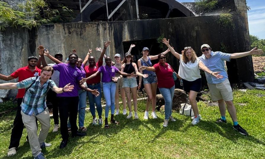 Marie and the group are posing with open arms outdoors, showing unity and joy